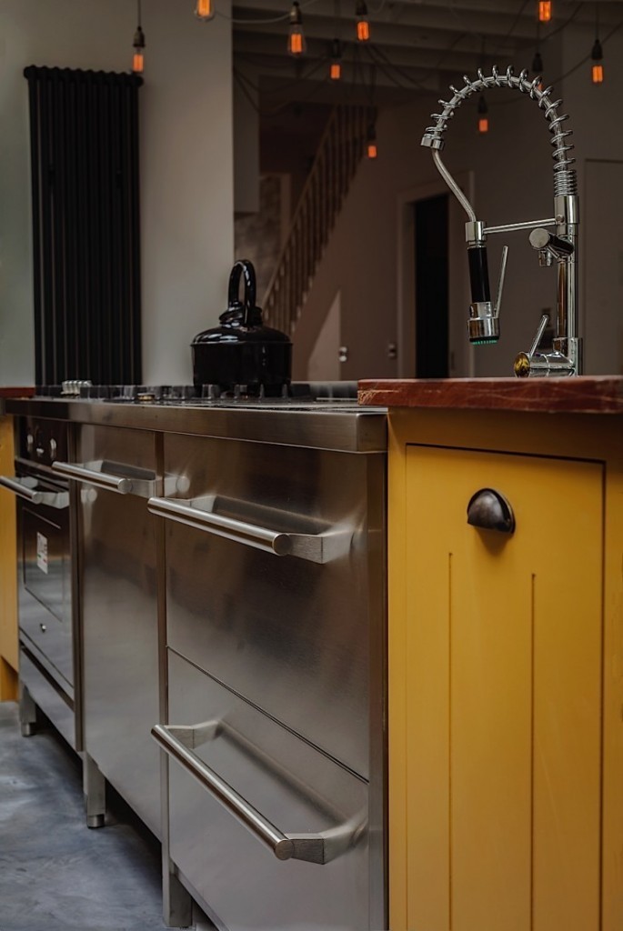 This industrial, contemporary kitchen space designed by RZ Living feature pendant lighting from Mullan Lighting