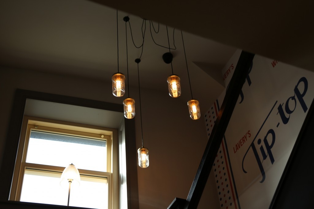 Jam jar cluster pendants from Mullan Lighting are suspended in the stairway of The Batch Loaf, Monaghan
