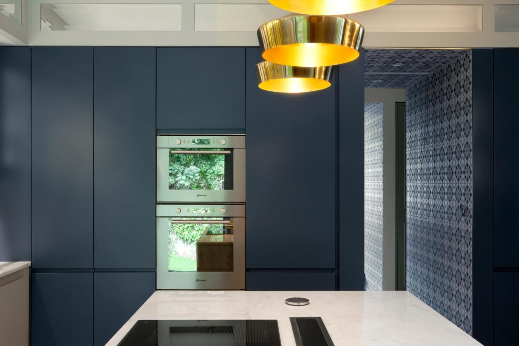 Brass kitchen lighting highlights the quartz island worktop of this Dublin residence