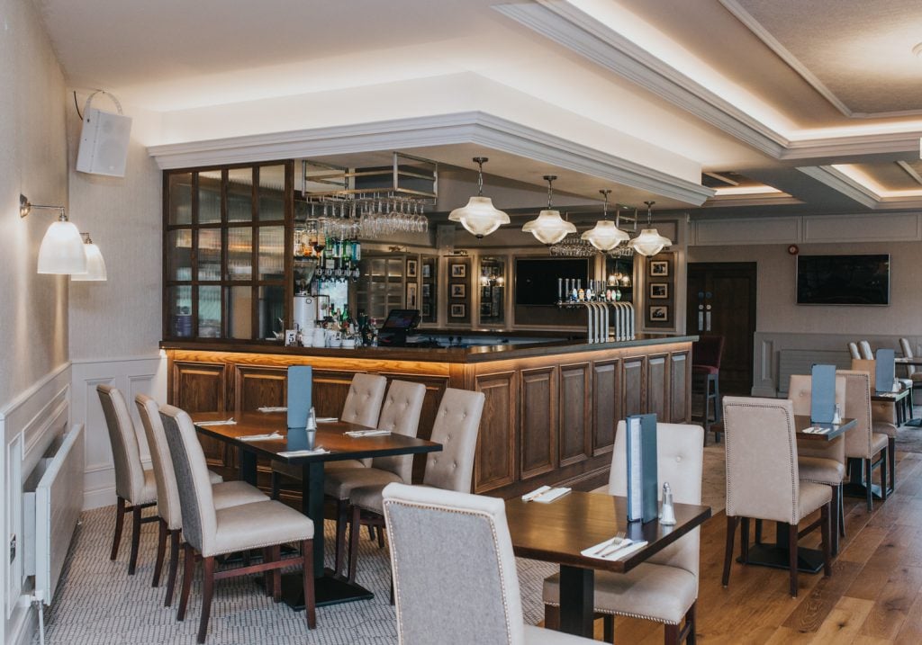 Our Hale wall lights and Essence double prismatic pendant lights above the main bar of the Foyle Golf Centre