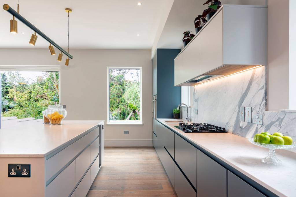 This modern kitchen space designed by Suzie McAdam Design and lighting from Mullan Lighting features handcrafted pieces by Michael Farrell Furniture n