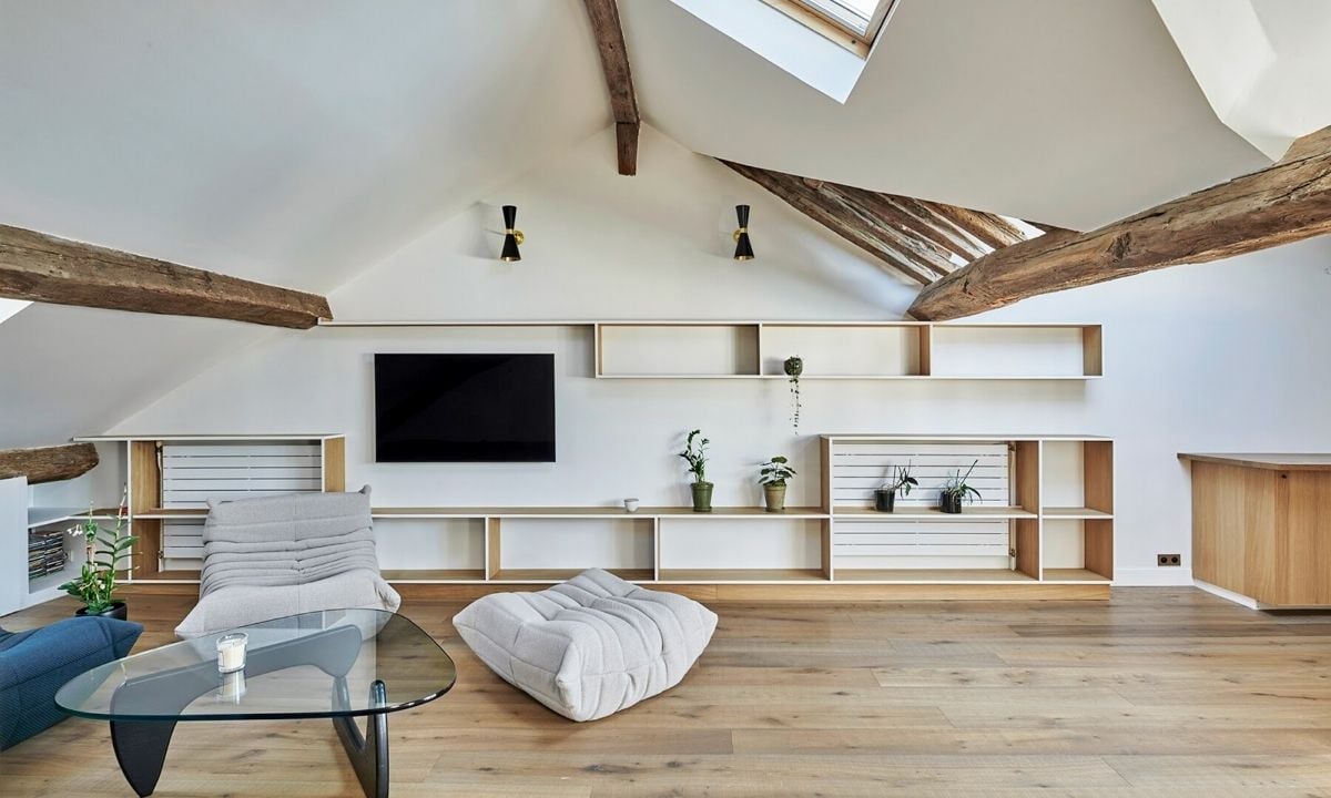 Slopped ceiling living space with wooden beams by Atelier ÉS
