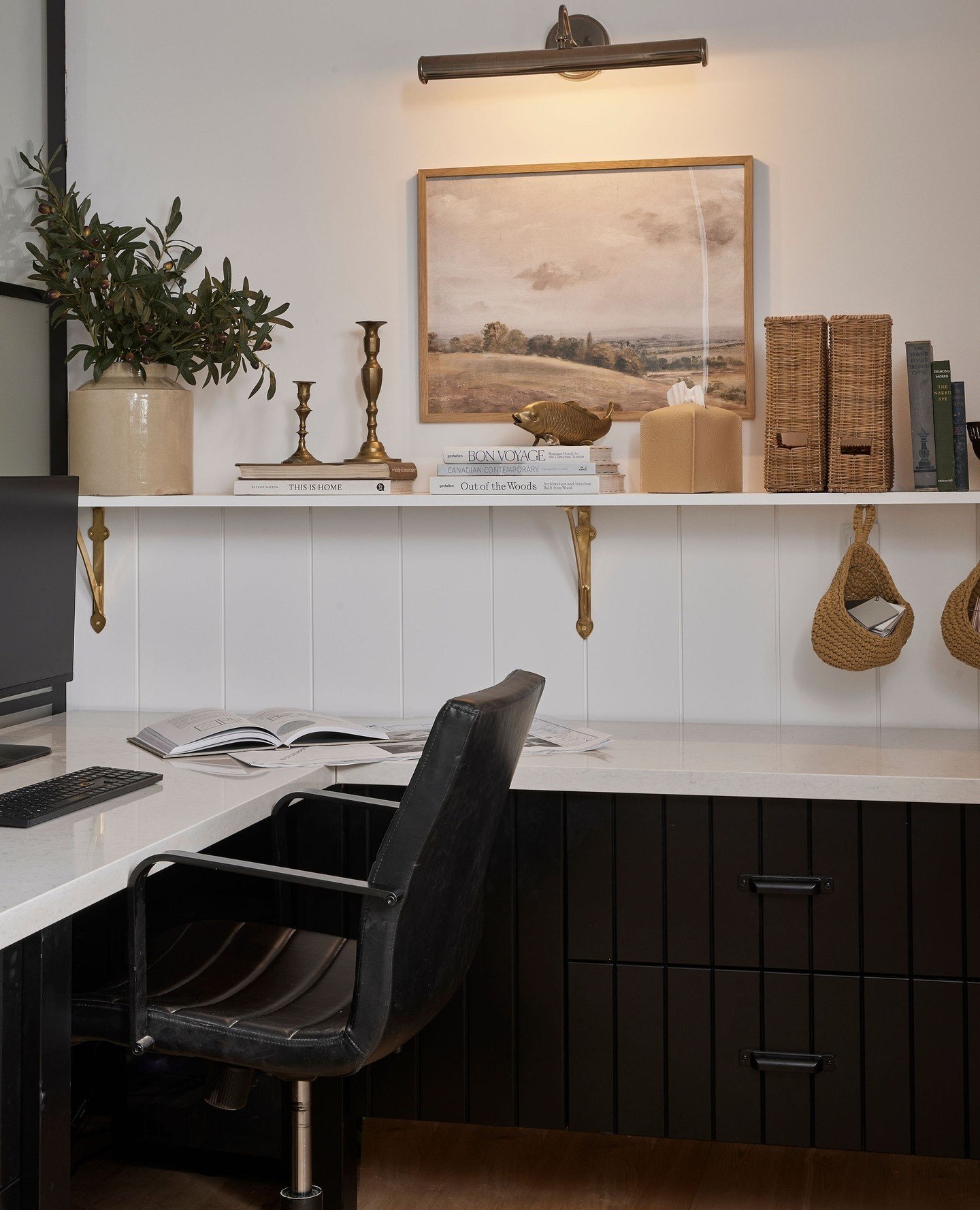 Picture light over modern desk area in office.