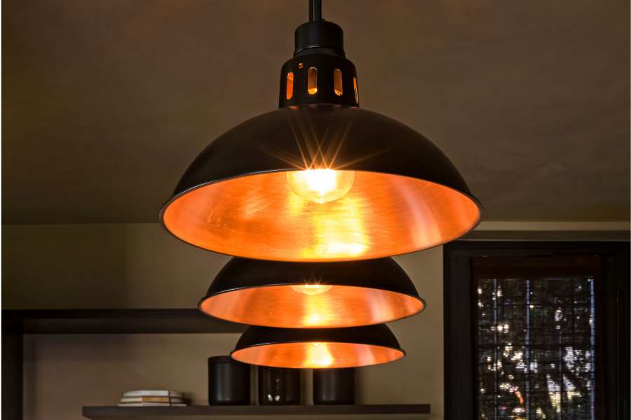 Three Bessemer pendant lights in a row in black and copper