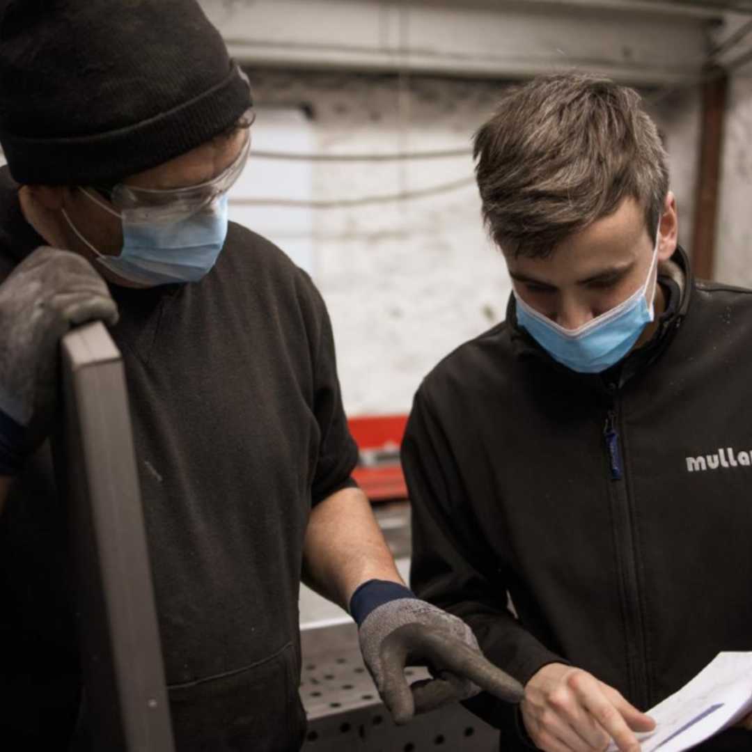 two guys discussing the details on a bespoke light