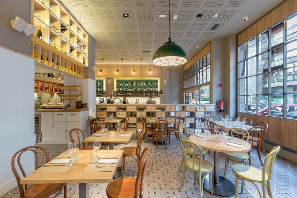 The Brussels pendant light is a factory-style pendant that adds an industrial aesthetic to this restaurant space.
